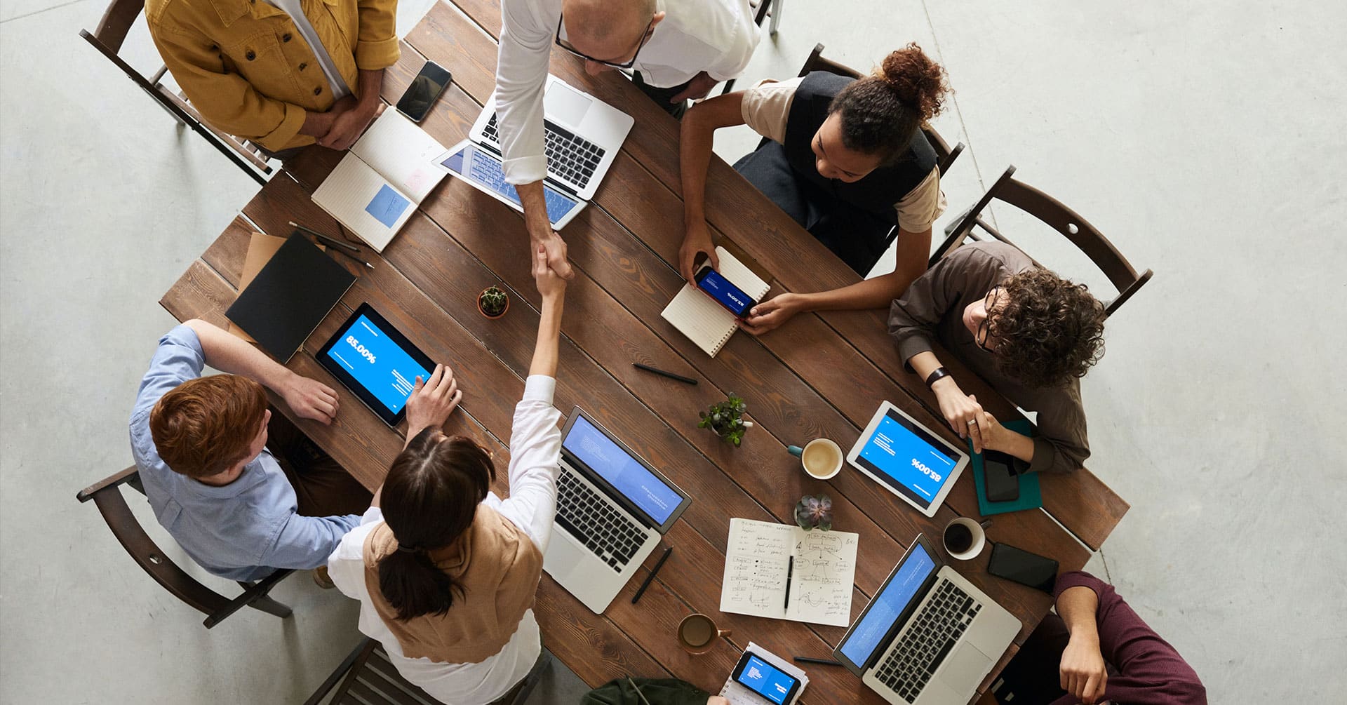 Group working meeting at large table to discuss phone answering services.