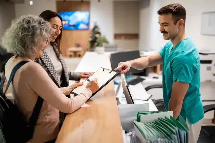 Patients checking in at medical clinic reception counter
